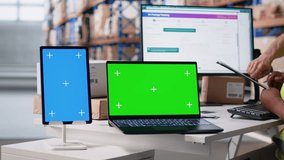Multiethnic team of warehouse workers next to green screen monitor. Managing shipping labels, barcode scanner data or e-commerce inventory tracking systems in industrial warehouse. Camera B. - Powered by Shutterstock - Get 15% off with code: PIKWIZARD15