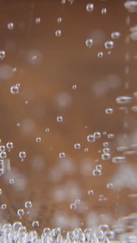 Dense concentration of gas bubbles creates fascinating underwater-like atmosphere in sparkling water with continuous carbonation movement producing ultimate ASMR viewing experience
