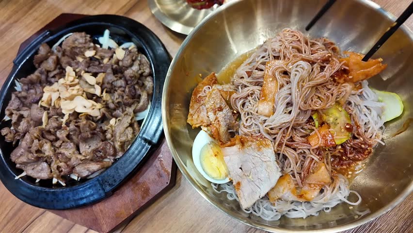 Korean cold noodles, naengmyeon. Stir the noodles with chopsticks.Bulgogi