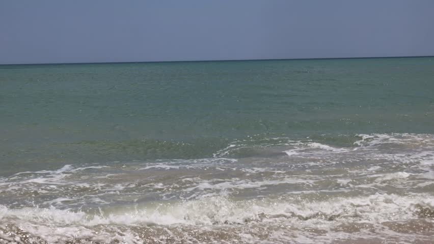 Ocean waves gently rolling toward the shore, creating a rhythmic and calming natural scene. Soft crests and flowing motion capture the beauty of the sea