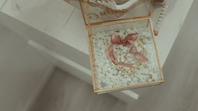 elegant glass ring box with pink ribbon heart and white flowers on wedding day table - Powered by Shutterstock - Get 15% off with code: PIKWIZARD15
