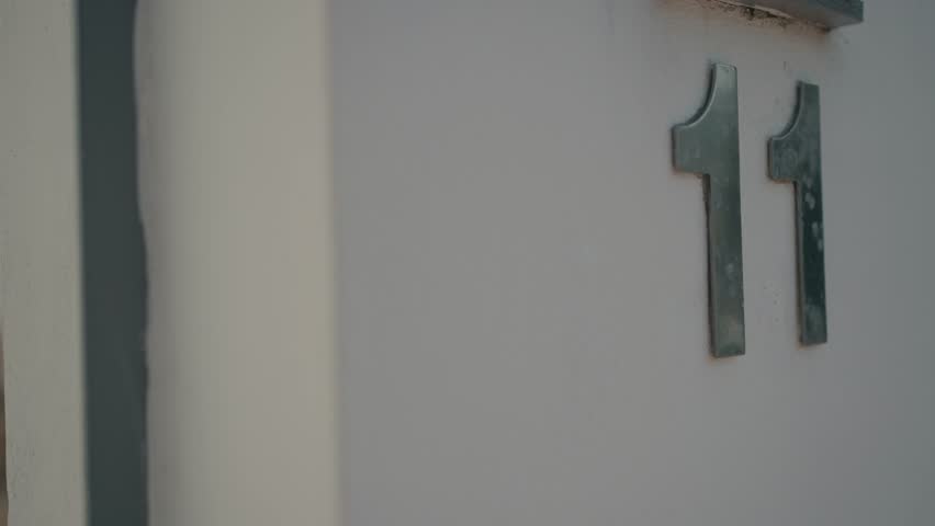 Sleek metal house number 11 on calm minimalist wall