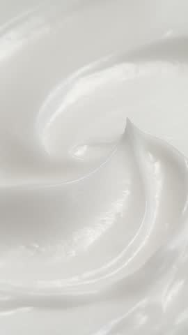 Vertical closeup white eye, skin cream texture background, facial cosmetics mask