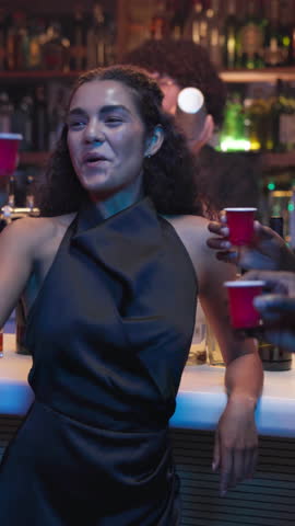 Cheers, shots and friends at bar in club with fun, excitement and party together at night. Smile, toast and group of people with alcohol drinks for happy hour at social gathering, event or reunion.