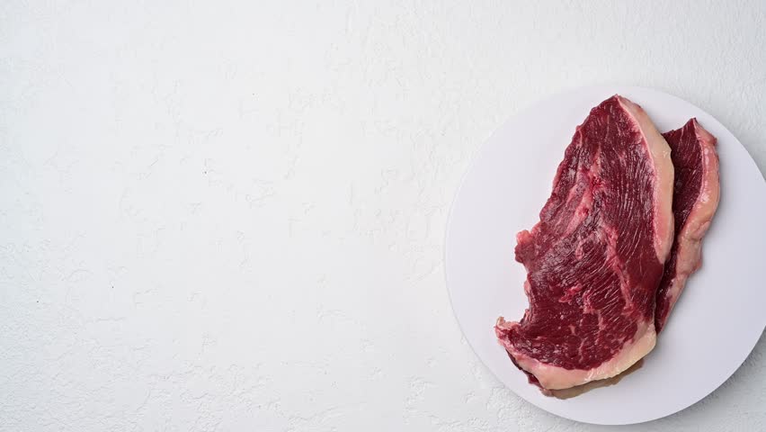 Raw picanha beef steak varieties displayed as marbled cuts on white plate in succession