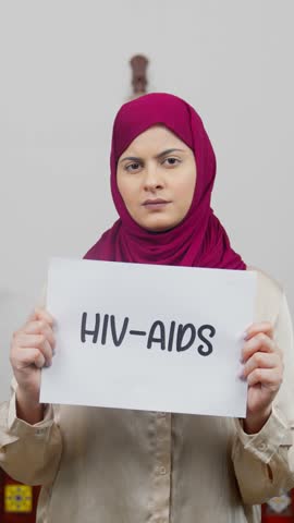 Vertical Video of Muslim Woman in Hijab Scarf standing with HIV-AIDS Poster
