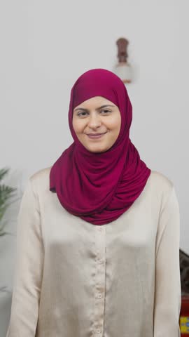 Vertical Video of Muslim Woman in Hijab Scarf standing with Trending Poster