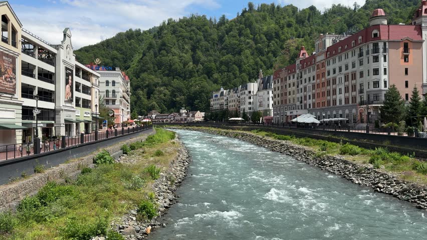 Mountain River Flowing Through European-Style Town with Scenic Sky