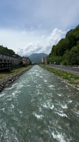 Mountain River Flowing Through European-Style Town with Scenic Sky