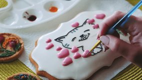 Close-up: Hand Painting Cute Cat Design on Frosted Cookie. Artistic Cookie Decoration Process with Edible Colors. - Powered by Shutterstock - Get 15% off with code: PIKWIZARD15