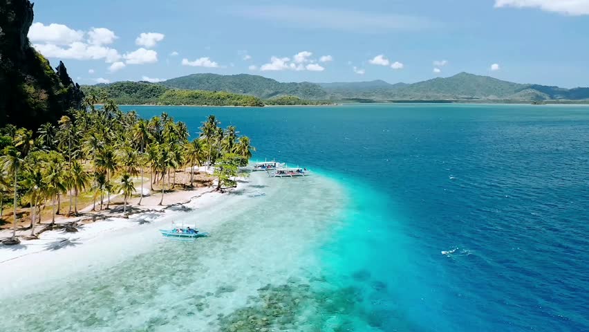 Stunning 4K aerial drone footage of a tropical island and clear turquoise water, under a sunny blue sky. Perfect for travel promos, island tourism, and nature documentaries.