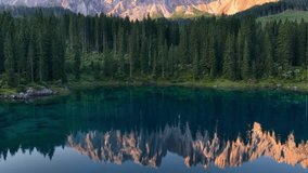 Meditative view of Karersee lake Dolomites, Italy, lake Carezza in the Italian Alps, peaceful scenic view of alpine lake at dawn with mirror reflection of mountain peaks in water.  - Powered by Shutterstock - Get 15% off with code: PIKWIZARD15