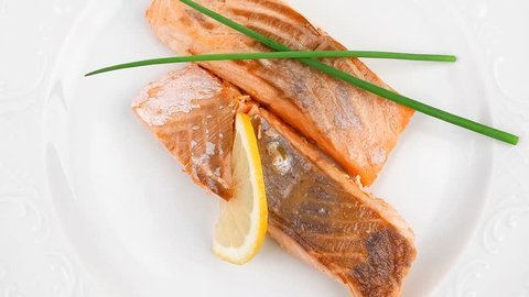 savory sea fish entree : roasted salmon fillet with green onion and lemon plate 1920x1080 intro motion slow hidef hd