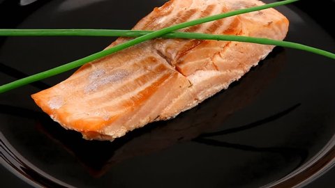 savory sea fish entree : roasted salmon fillet with green onion on black dish 1920x1080 intro motion slow hidef hd