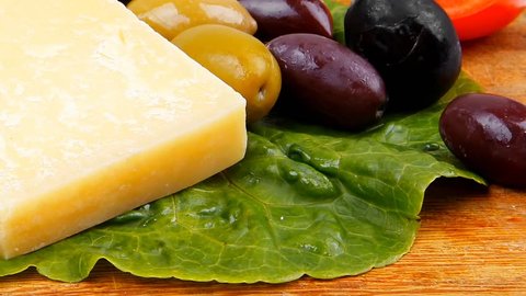 gold swiss cheese on wooden platter with olives and tomato 1920x1080 intro motion slow hidef hd