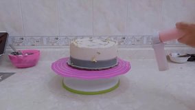 Professional baker decorating frosted cake, carefully applying delicate gold leaf for luxurious finishing detail - Powered by Shutterstock - Get 15% off with code: PIKWIZARD15