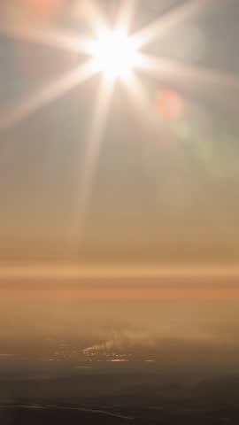 Sun with rays slowly setting behind horizon in timelapse, dusk sky darkening