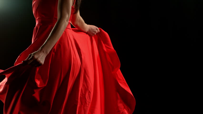 Brunette Woman in Ruby Red Dress Posing Against a Black Background . Filmed on High Speed Cinematic Camera in Super Slow Motion