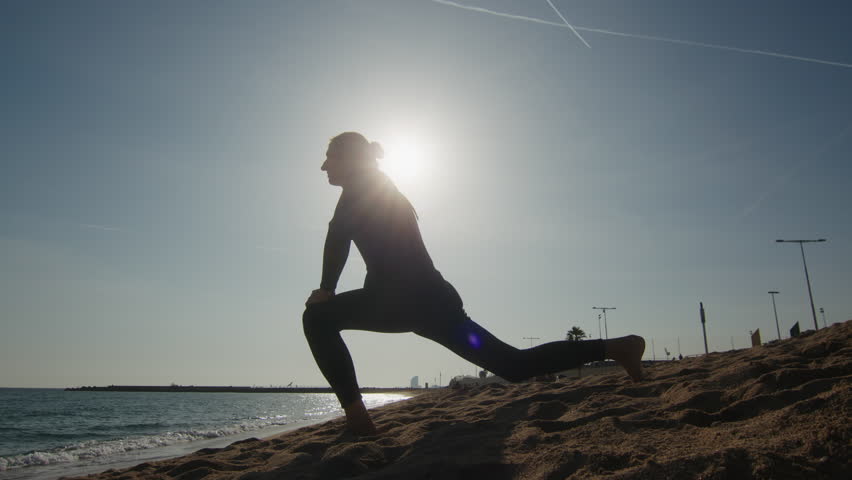 Surfer man walking to the beach at sunset preparing for surfing training and search for waves in Barcelona, spain, water, ocean exercise in sea with board, athletic male holiday or travel in vacation.