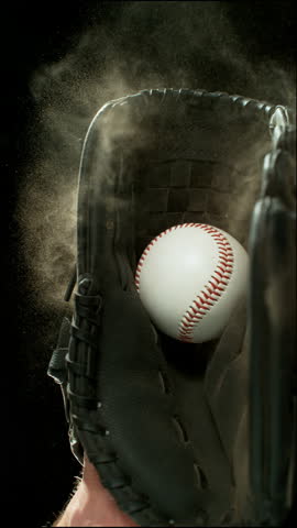 Super slow motion of hand in brown leather baseball glove caught ball isolated on black background . Filmed on high speed cinematic camera