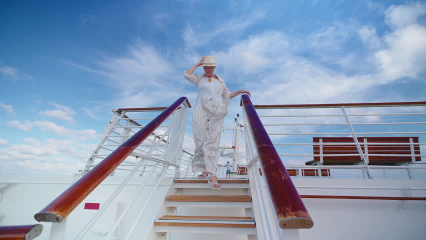 A stylish woman gracefully descends the elegant stairs of a beautiful cruise ship, with a stunning blue sky overhead, creating an enchanting, serene, and captivating atmosphere around her