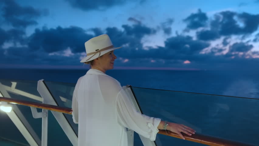 A woman enjoys a beautiful sunset on a cruise ship deck. The breezy atmosphere and stunning ocean views provide a peaceful escape from everyday life, allowing her to appreciate natures beauty