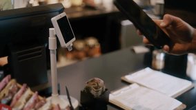 Barista processing contactless payment from customer using smartphone at cafe checkout - Powered by Shutterstock - Get 15% off with code: PIKWIZARD15