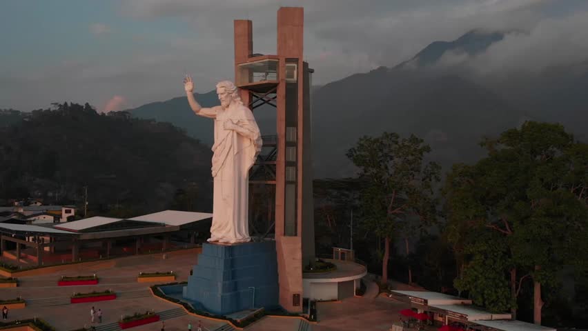Drone footage of Cerro del Santísimo Park in Floridablanca, Santander, Colombia. Features the towering Christ monument surrounded by lush vegetation, mountains, and scenic viewpoints. A top tourist