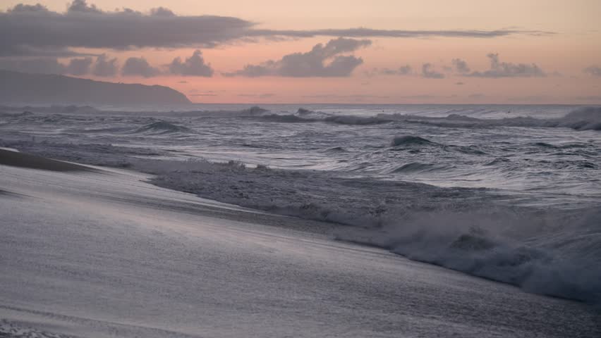 Hawaiian waves crashing on beach at sunset Honolulu Hawaii 