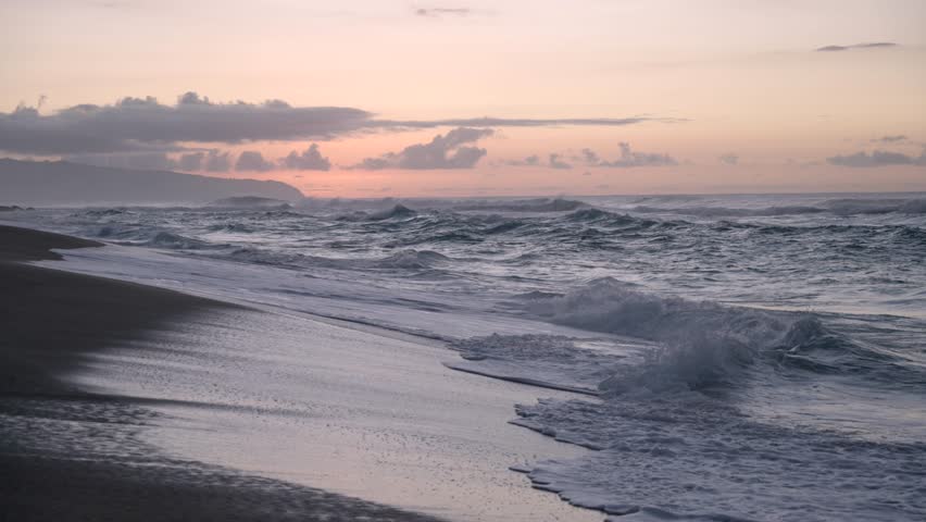 Hawaiian waves crashing on beach at sunset Honolulu Hawaii 