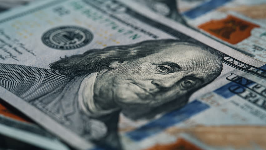 Detailed photo of Franklin face printed on modern one hundred note. Stack of fresh american paper bills scattered across smooth table. Pile of financial cash forming background for money theme indoors