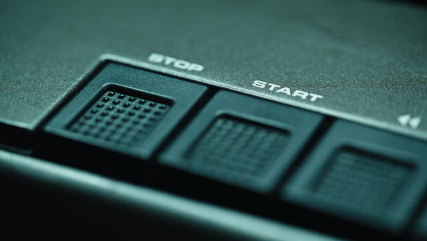 Finger pressing start button on old retro tape player closeup. Macro view hands touching music equipment. Unrecognizable man starting recording sound indoors. Vintage nostalgia and technology concept