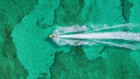 Aerial footage captures a jet ski gliding over Cozumels clear turquoise waters, showcasing the vibrant marine life beneath, inviting viewers to explore this tropical paradise and its natural beauty - Powered by Shutterstock - Get 15% off with code: PIKWIZARD15