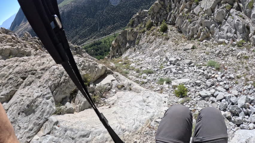 POV shot of a solo speedflyer flying extremely fast and risky over terrain, with the pilot’s shadow visible on the ground, enhancing the sense of speed and danger.
