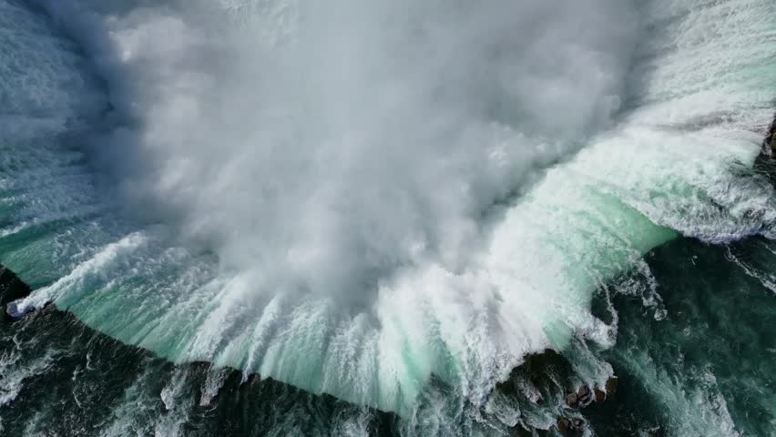 Downward-facing drone captures the powerful currents of Horseshoe Falls up close, then ascends to reveal the full sweeping view of the iconic waterfall