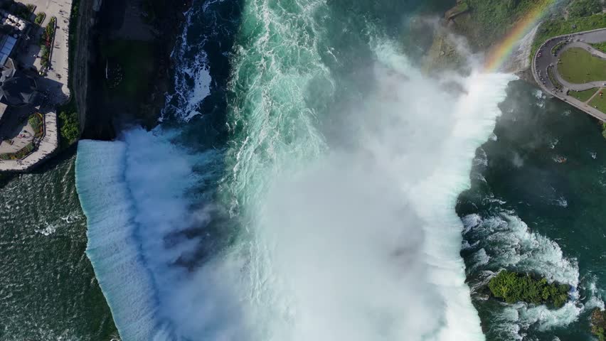 Drone captures a downward-facing, close-up shot of Horseshoe Falls, flying sideways to reveal the full span of the waterfall and its powerful cascading currents