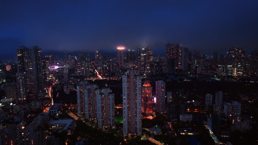 A hyperlapse aerial shot of Mumbai city at night, showcasing the dynamic cityscape illuminated with vibrant lights. Perfect for themes of finance, technology, infrastructure, metropolitan lifestyle.