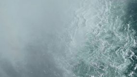 Downward-facing drone shot of the Maid of the Mist cruise ship navigating toward the powerful swirling currents near the base of Horseshoe Falls through rising mist - Powered by Shutterstock - Get 15% off with code: PIKWIZARD15