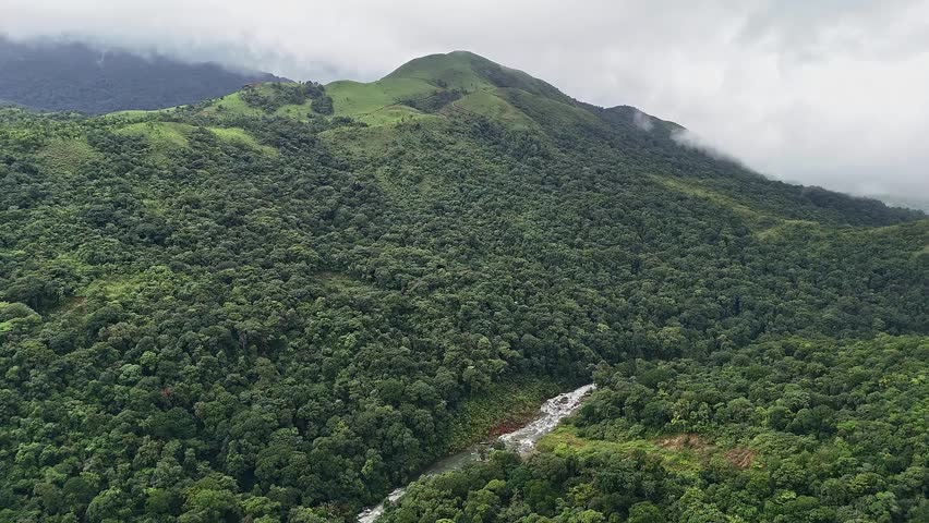 An epic aerial view of Mallalli Waterfalls flowing amidst lush green mountains and forests during the rainy day.mesmerizing view of a secret waterfalls amidst jungle.tourism concept.travel concept