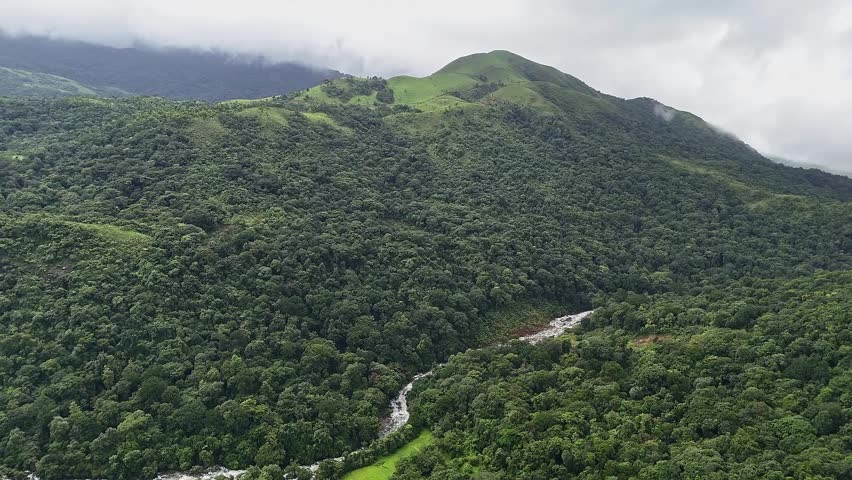 An epic aerial view of Mallalli Waterfalls flowing amidst lush green mountains and forests during the rainy day.mesmerizing view of a secret waterfalls amidst jungle.tourism concept.travel concept