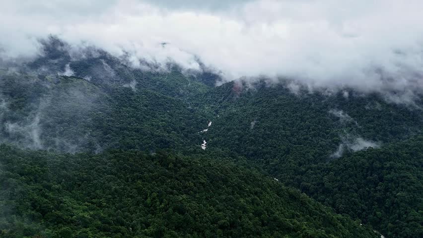 An epic cinematic drone view of a cascading mallalli waterfall, lush mountains, and forests topped with misty clouds during the monsoon season in western ghats of karnataka.travel concept