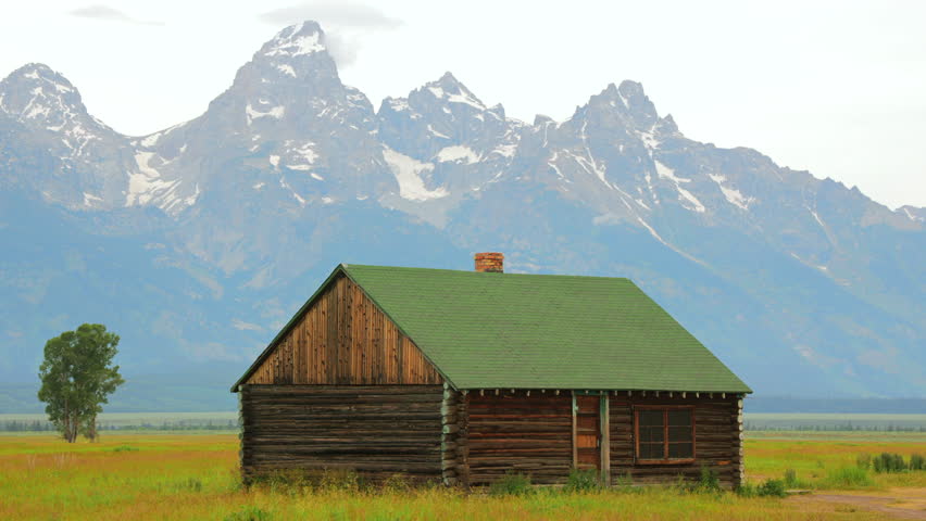 Imagine a picturesque wooden cabin set against a stunning mountain backdrop, surrounded by vibrant greenery. This setting is ideal for nature and landscape photography enthusiasts