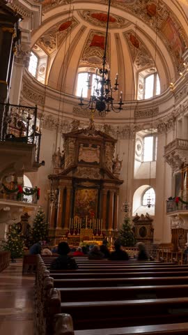 Salzburg, Austria - December 23, 2024: Ornate Baroque interiors of Salzburg Cathedral with gilded details. Timelapse, Zoom out transition, vertical orientation.