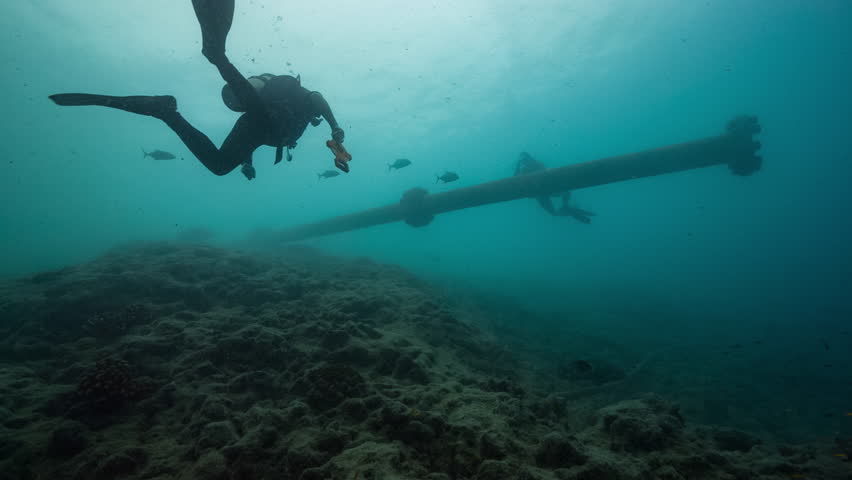 SCUBA Divers explore mysterious wreckage on the reefs of Nikumaroro Atoll, Kiribati