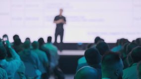 Speaker presenting on stage to a seated audience during business seminar. Conference attendees listening to informative talk. - Powered by Shutterstock - Get 15% off with code: PIKWIZARD15