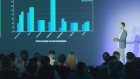 Speaker presenting data visually with graphs to an audience in professional environment - Powered by Shutterstock - Get 15% off with code: PIKWIZARD15