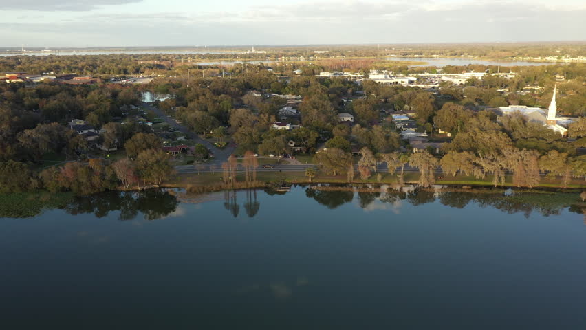 Lush Trees And Coastal Road On The Private Lake In Winter Haven In Polk County, South Florida, USA. Aerial Drone Shot