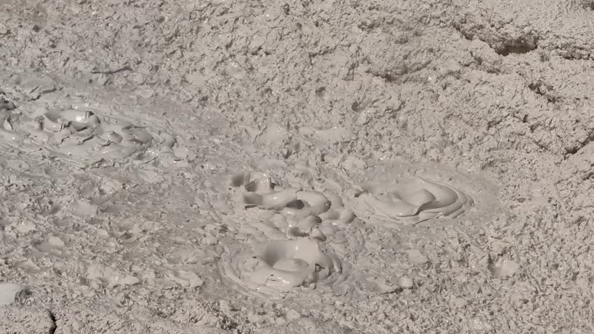 Bubbling mudpot pool of hot splashing mud on the Artists Paintpots Trail in Yellowstone National Park. 