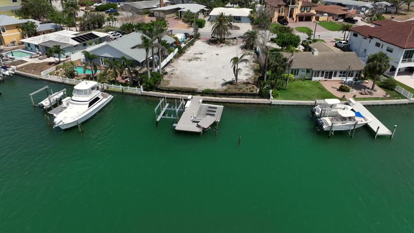 Empty property with private jetty pier in Florida. Aerial top down. Building phase construction site in neighborhood. Approaching shot. Empty building ground.