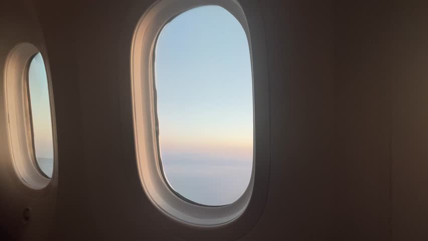 Scenic view from an airplane window overlooking the sparkling sea near Barcelona, with coastline, blue waters, and sunny skies creating a serene aerial travel experience.


